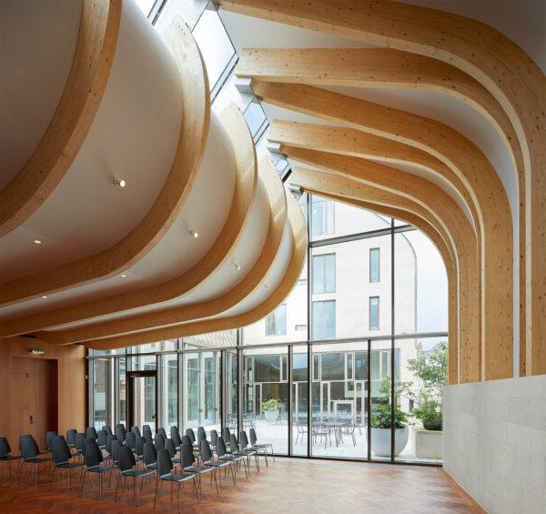 A photograph of the Cohen Quad at Exeter College, designed by Alison Brooks Architects, showcasing the firm's expertise in adaptive reuse and conservation-focused heritage architecture. The image highlights the project's sensitive integration of new and historic elements. Below the image, the text states that Alison Brooks Architects has won the Best Medium Firm prize for the Architizer A+ Awards, which is recognized in over 80 countries.